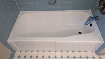 2025-06-29 13-05-26 Refinished white bathtub surrounded by blue tile in a bathroom.